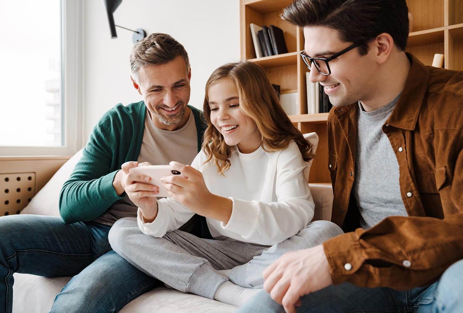 Dads and daughter using mobile device together